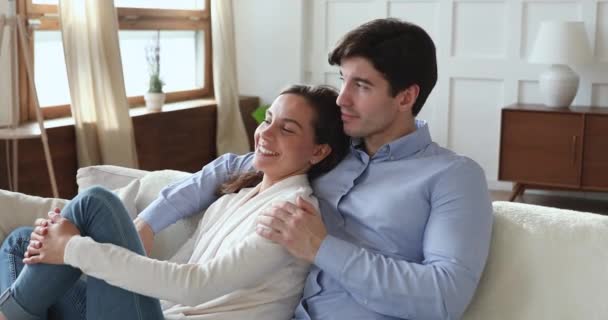 Relaxed romantic young couple lounging on sofa at home — Stock Video