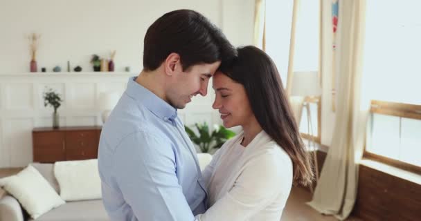 Счастливая романтическая пара обнимается, глядя в камеру дома — стоковое видео