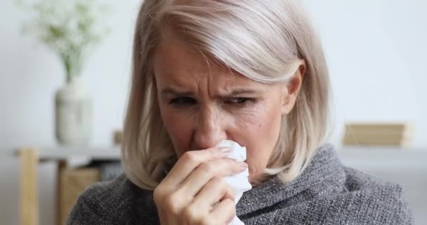 Middle aged female retiree caught cold, sneezing. — Stock Video