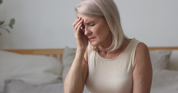 Utmattad äldre mogen kvinna som lider av stark huvudvärk. — Stockvideo