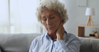 Boyun ağrısı çeken orta yaşlı bir kadın..