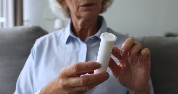 Cerca de mujer de mediana edad sosteniendo botella de plástico con pastillas . — Vídeos de Stock