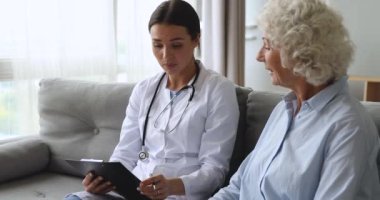 Genç profesyonel pratisyen hekimin sağlık kontrolü sırasında kart yazması.