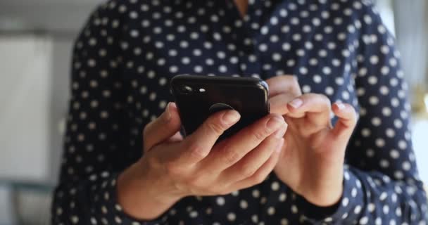 Nahaufnahme einer jungen Frau, die ihr Smartphone in der Hand hält und mobile Anwendungen nutzt. — Stockvideo
