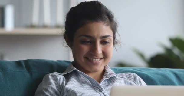 Happy indian woman relaxing on couch, using computer at home. — Stock Video