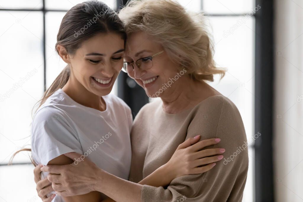 Loving mature mom hug cuddle happy adult daughter