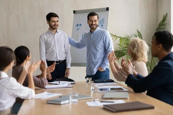 Empresário animado apresenta recém-chegado do sexo masculino na reunião do escritório — Fotografia de Stock