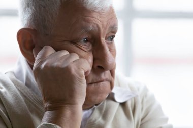 Yakından yaşlı adam hayal kırıklığına uğramış ve üzgün düşüncelerde kaybolmuş.