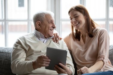 Yetişkin bir kız. Yaşlı babası birlikte zaman geçiriyor. Tablet kullanıyor.