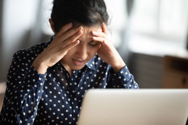 Mutsuz Hintli kadın tapınaklara dokunuyor, kendini kötü hissediyor.