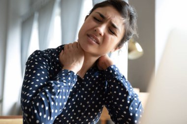 Mutsuz Hintli kız masaj yapıyor, boyun kasları sertleşiyor.