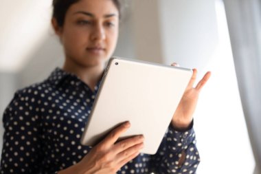 Bilgisayar tableti kullanan odaklanmış Hintli kadını kapat