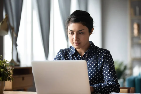 Donna indiana seria che lavora sul computer portatile, guardando lo schermo — Foto Stock