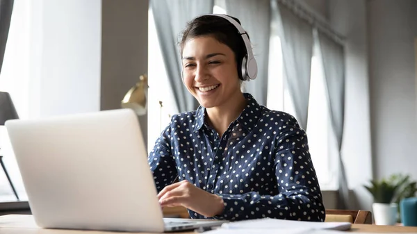 Smiling Indian girl wearing headphones using laptop, working online — Stock Photo, Image