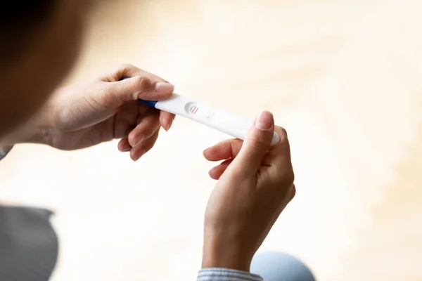 Close up Indian woman holding pregnancy test with two lines — Stock Photo, Image