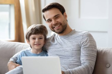 Laptop kullanan küçük baba ve oğlunun portresi.
