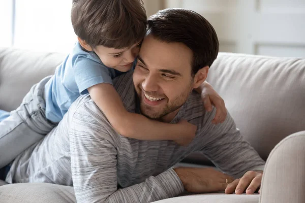 Niño preescolar relajarse en casa con papá joven —  Fotos de Stock