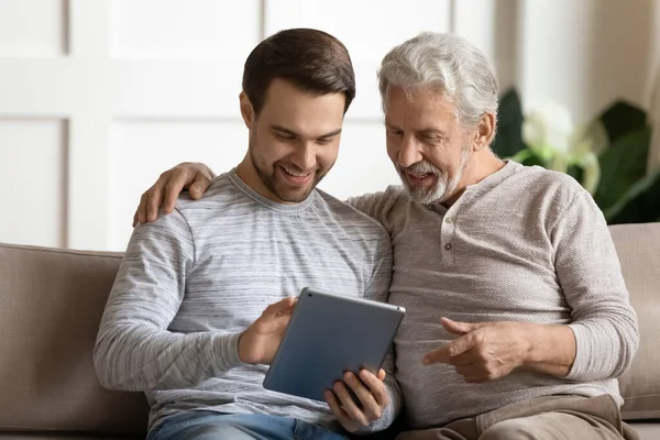 年长的父亲和成年的儿子一起使用平板电脑 — 图库照片