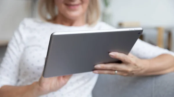 Close up pleasant elder female retiree holding digital tablet. — Stock Photo, Image