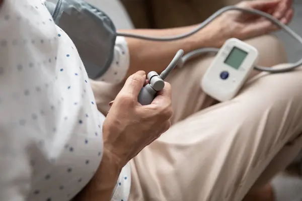 Close up older woman using semi-automatic digital tonometer. — Stock Photo, Image