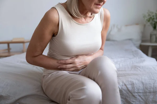 Unhealthy woman embracing belly, suffering from strong stomach ache. — Stock Photo, Image
