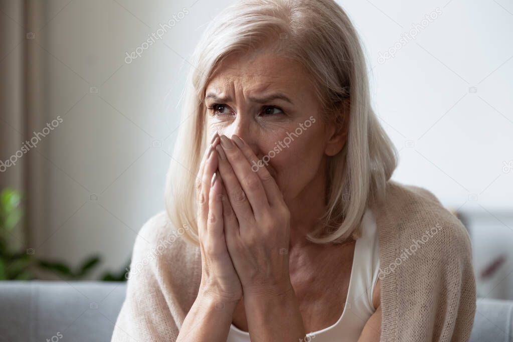 Head shot close up depressed middle aged woman crying.