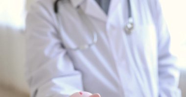 Kumbarayı tutan yaşlı erkek doktor, manzarayı kapat.
