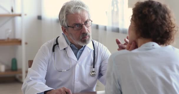 Amigável médico sênior masculino desgaste casaco branco consultoria paciente feminino — Vídeo de Stock