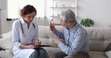 Bayan doktor, yaşlı hastayı muayene ediyor. Büyükbabayı ziyaret ediyor.