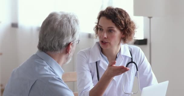 Médico femenino explicando prescripción a cliente senior enfermo — Vídeos de Stock