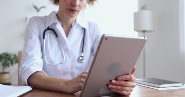 Primer plano del médico femenino utilizando la aplicación de tabletas digitales en el lugar de trabajo — Vídeo de stock