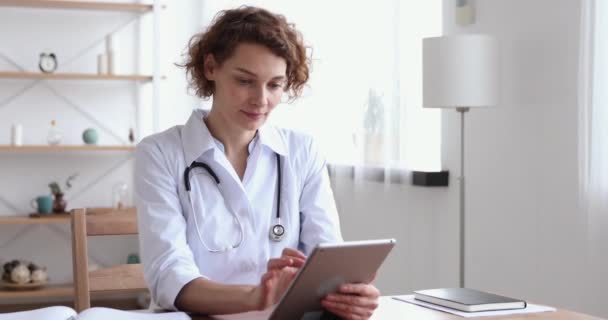 Feliz médico profesional femenino usando tableta digital en el trabajo — Vídeo de stock
