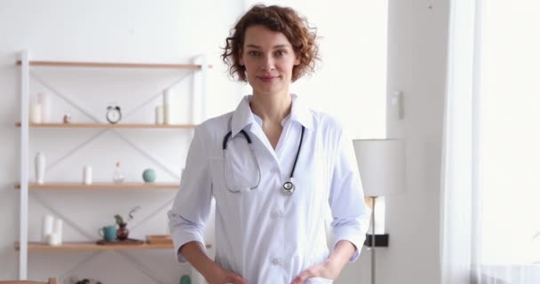 Zelfverzekerde duizendjarige vrouwelijke therapeut poserend in medisch kantoor, portret — Stockvideo