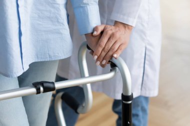 Kadın doktor engelli yaşlı kadına yardım ediyor.