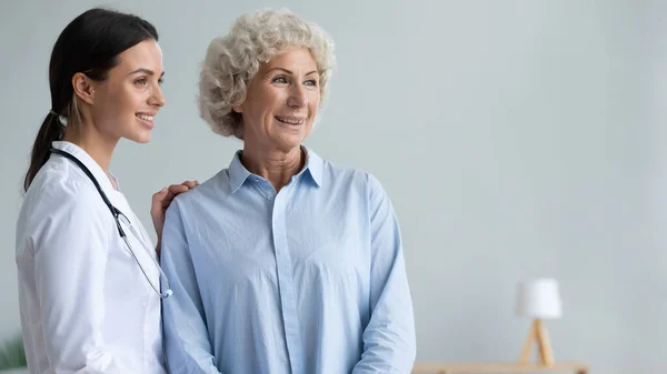 Female nurse and senior patient dream look in distance dreaming — Stock Photo, Image