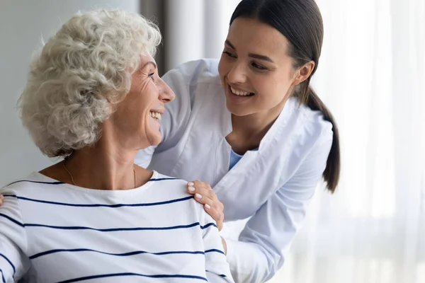 Caring young nurse assist handicapped mature female patient — Stock Photo, Image