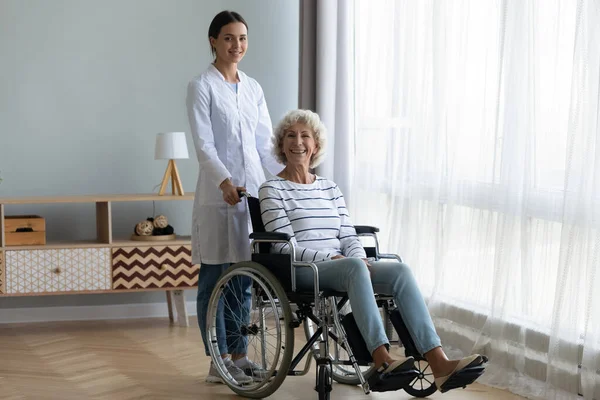 Caring female nurse support disabled senior woman patient — Stock Photo, Image