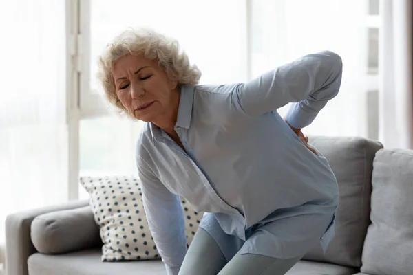 Sick mature woman stand up suffer from rheumatism at home Stock Image