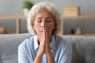 Kıdemli bayan inançlı evde dua eden eller dua eder.