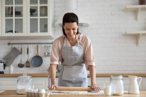Mujer joven sonriente haciendo pasteles para hornear masa —  Fotos de Stock