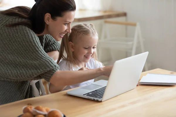 Smiling mother and small daughter using laptop together — Stock Photo, Image