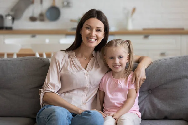 Portrait of happy mom and daughter cuddle at home — Stock Photo, Image