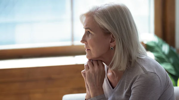 Unhappy lonely older woman sitting alone and thinking about problems — Stock Photo, Image
