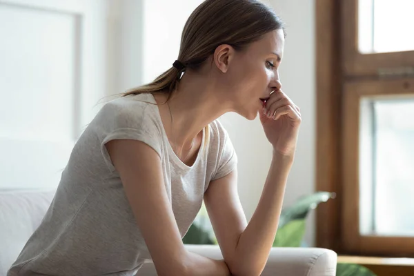 Profil verärgert nachdenkliche Frau, die sich in Gedanken verliert und allein sitzt — Stockfoto