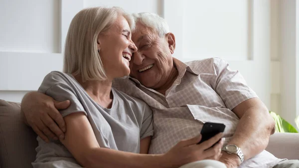 Boldog idősebb feleség és férj ölelés, telefon használata együtt — Stock Fotó