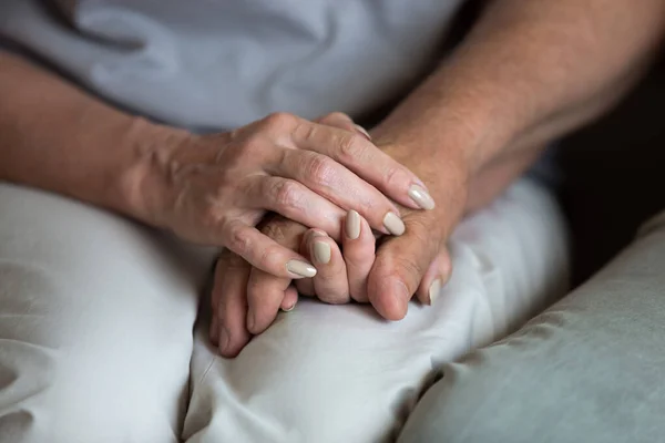 Cerca de la mujer de mediana edad sosteniendo las manos del marido mayor — Foto de Stock