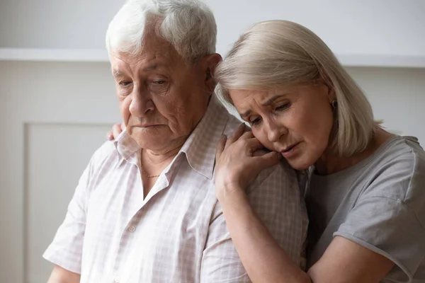 Ongelukkig vrouw van middelbare leeftijd ondersteunen en troosten oudere man — Stockfoto