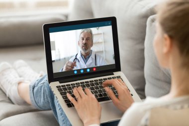 Kadın hasta video kullanarak çevrimiçi doktorla görüşüyor.