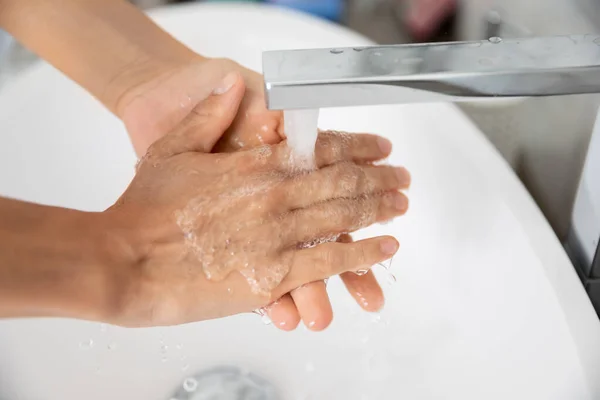 Closeup view caucasian woman cleans hands under running water