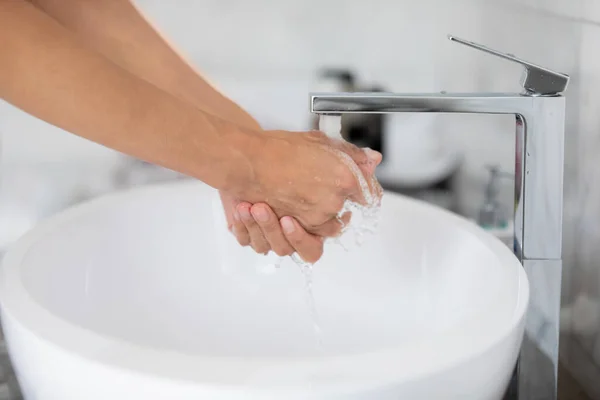 Vatten häll från kranen medan kvinnan tvätta händerna närbild — Stockfoto